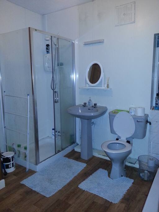 Bathroom with electric shower and bath tub