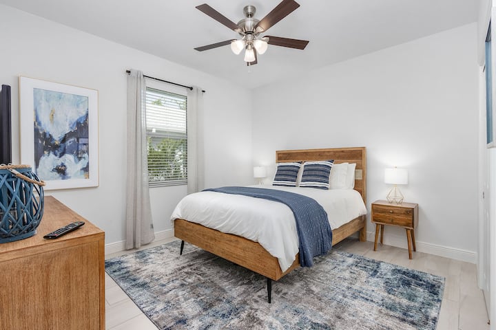 Სტუმრების საძინებელი დიდი ზომის საწოლით, კარადათი და სმარტ-ტელევიზორით.