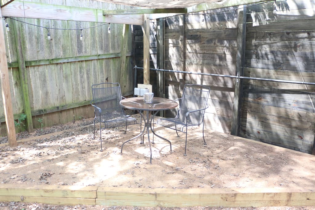 Enjoy your own covered backyard space with outdoor lighting and patio table.