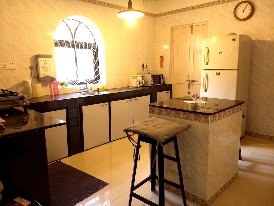 Common kitchen with stove, microwave, fridge, water, utensils and other amenities
