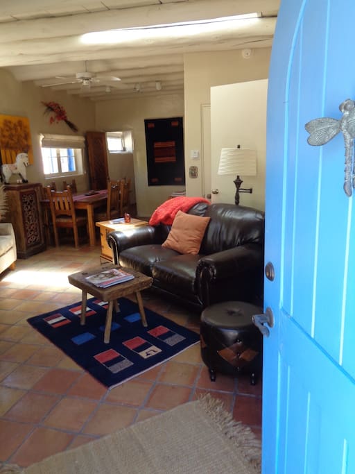 The bright blue front door, very typical throughout Santa Fe and also Taos, opens into the cozy living room area.