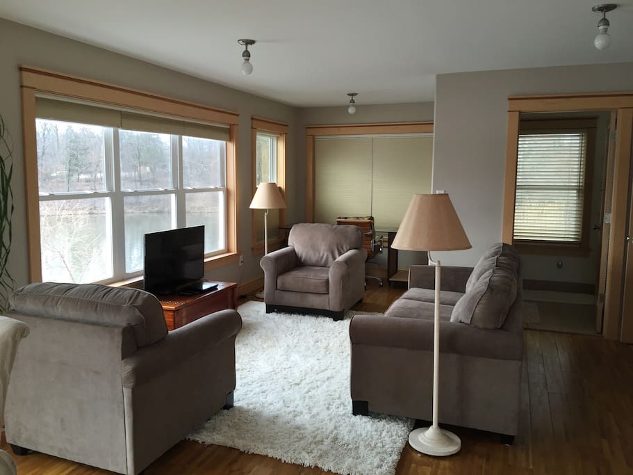 Living room/ Kitchen/ Dining has views of Walton Lake in 3 directions. HD TV, BlueRay player, desk in background.