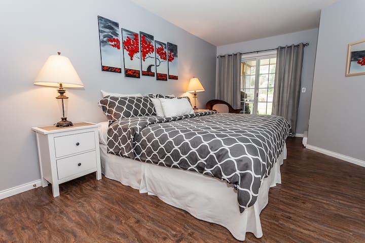 宽敞的主卧配备加大双人床，可俯瞰露台、水景和草坪区域