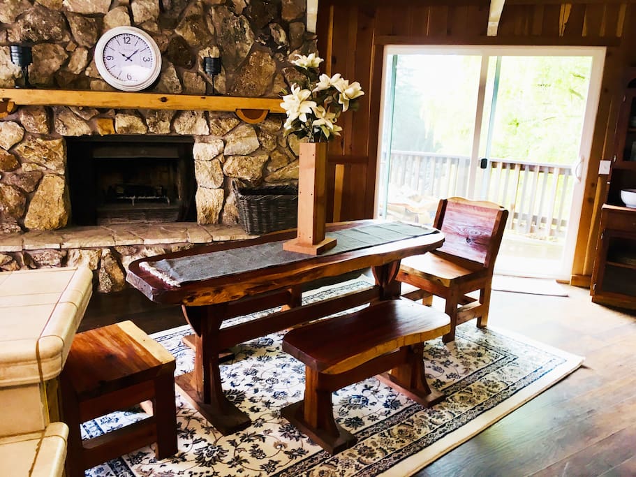 Dining area with custom handcrafted redwood slab table and benches. Wood for fire available by request.
