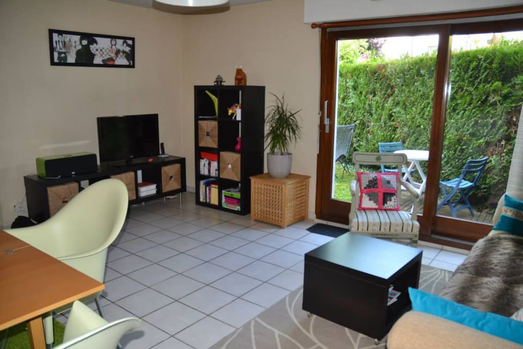Salon / salle à manger avec baie vitrée donnant sur terrasse et jardin