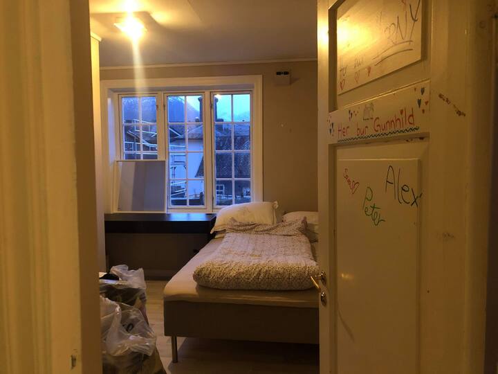 Soverom med dobbelseng og skrivebord. Døra er "kjendisdøra" fra serien Lovleg på NRK, som var filma i denne leiligheten. 