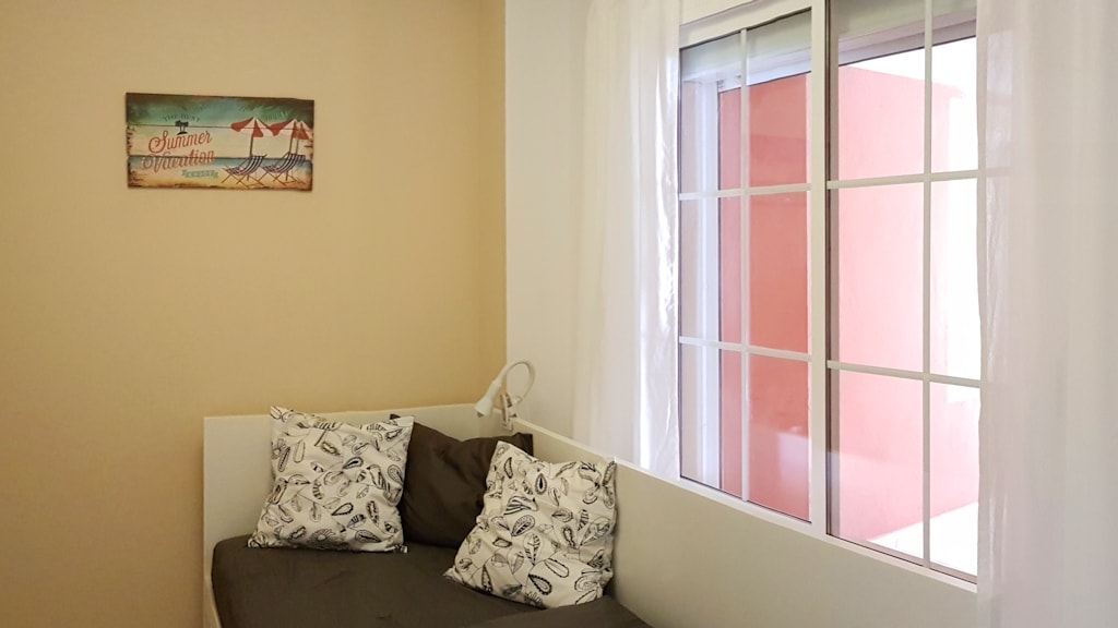 2. Dormitorio muy pequeño con cama individual extraíble y ventana.