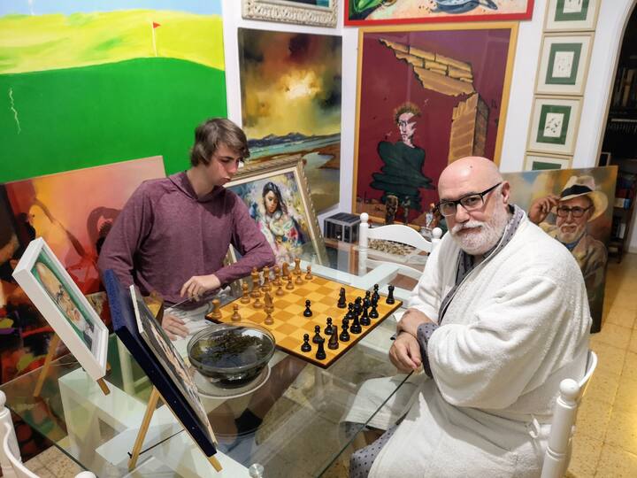 Una entretenida partida de ajedrez con un joven visitante de Airbnb en el salon del comedor. 