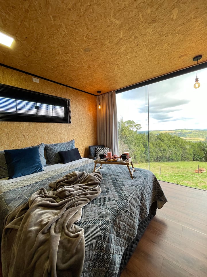Quarto com vidro que integra você a natureza, adormecer e acordar com uma vista dessas, é uma experiência única. 