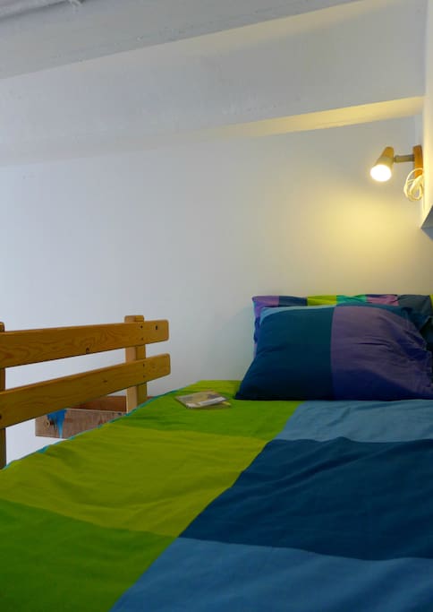 The single bedroom has a large bed with reading light