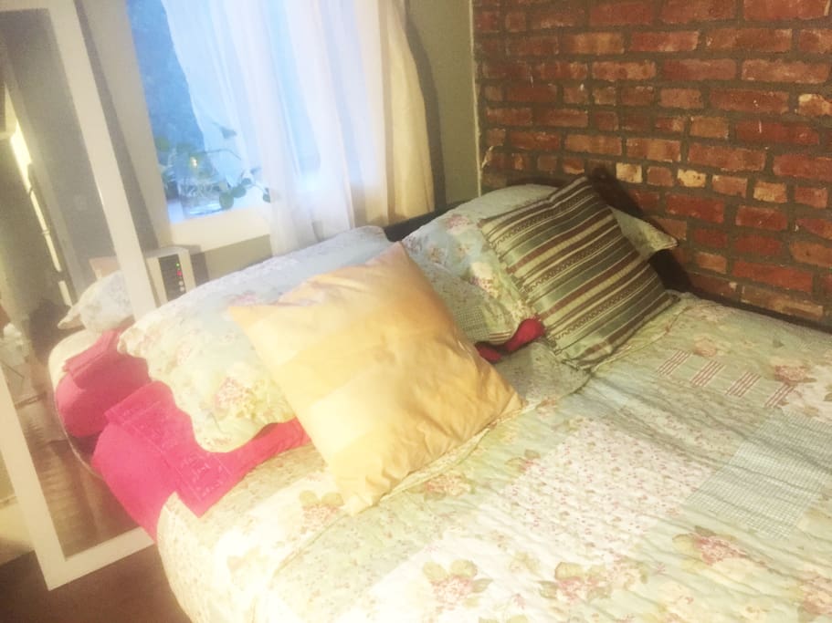 Beautiful view of wildflower garden from bed! Step out the window and enjoy the morning sun on the fire escape or relax on our finished roof with stunning views of lower Manhattan and the East River! Away from street, no traffic noise! Forget you're in the city for a little while!