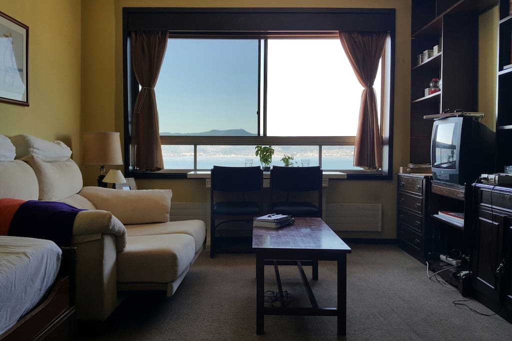 Spacious living room with comfy couch, TV, extra bed, and the most amazing breakfast spot ;)