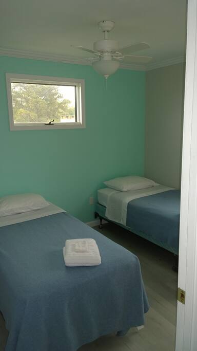 Bedroom two, with twin beds. Notice both bedrooms and living room have new ceiling fans.