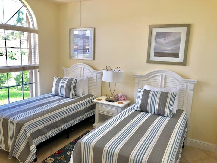 1号双床卧室，配有两张单人床、智能电视和内置衣柜