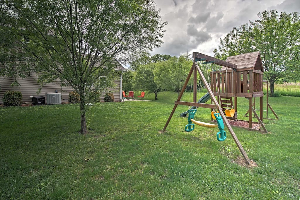 A large yard with a playset creates the perfect space for kids to play.