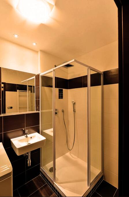 The bathroom has a shower cabinet, washing machine, wash basin, and a toilet seat.