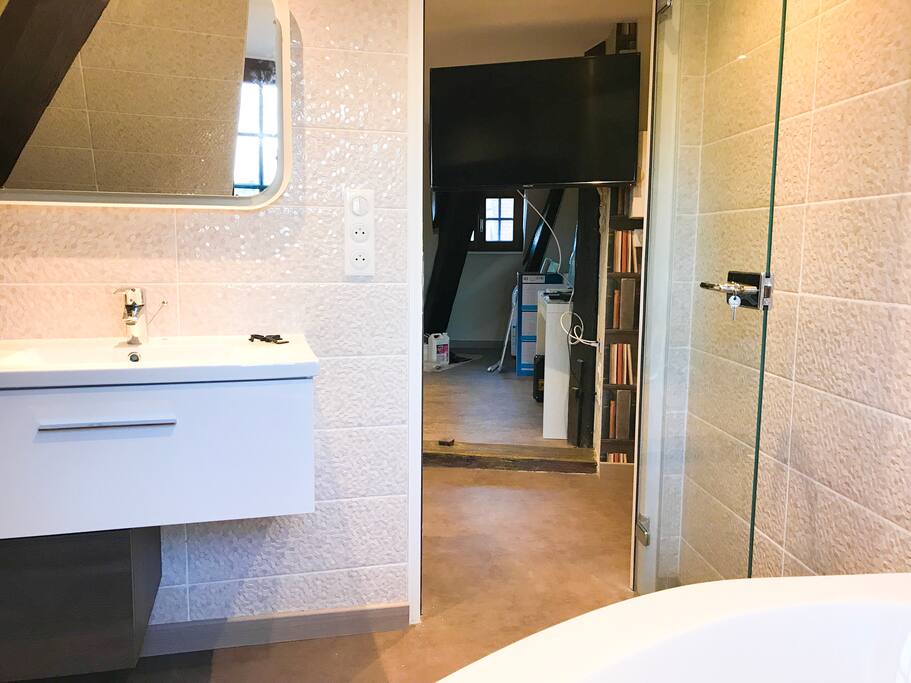 Salle de bain avec vue sur la tv