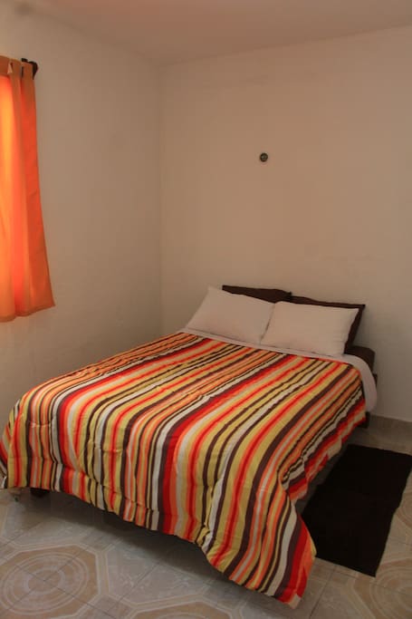 Habitación No. 1 con aire acondicionado, tocador, closet y plancha para ropa.