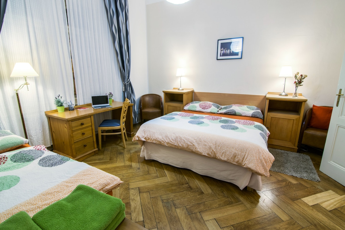 Slaapkamer met 2 persoons bed, 1 persoons bed, kledingkast en bureau. Slaapkamer is verbonden met badkamer