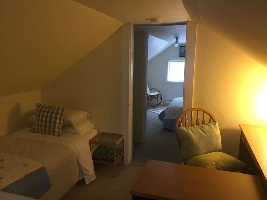 View from the first single room in the loft through to the double room. There is a desk and wardrobe space.