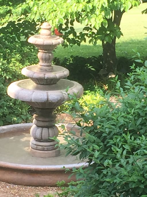 Soothing large water fountain for birds and pollinators in a peaceful sitting garden.
