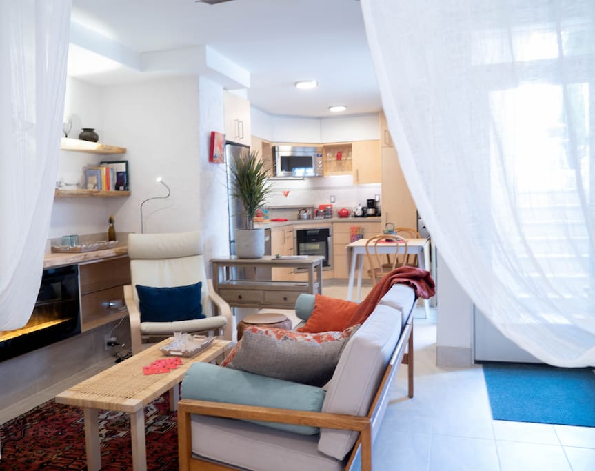 Living room with kitchen area in background.