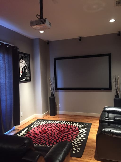 living room with 90 inch projector screen and Bose speakers perfect for movies and to watch the game.