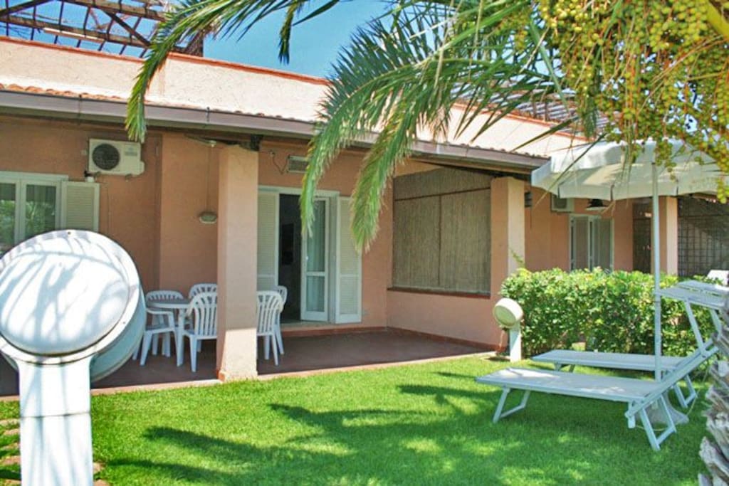 Back yard with dining table, beach umbrella and beach chairs