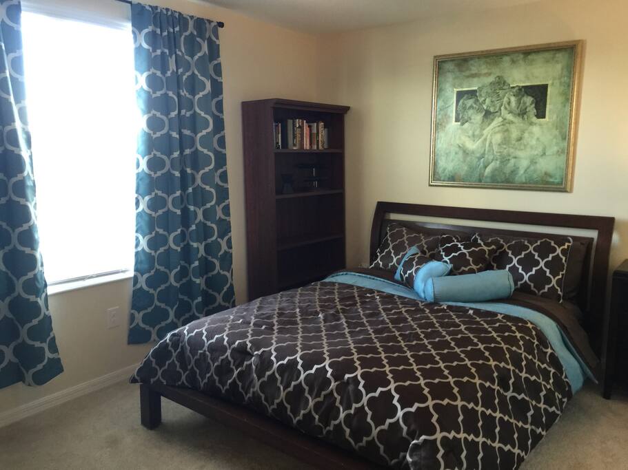 Queen size bed with books and plenty of plus for all your electronics