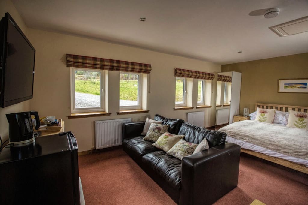 Room is decorated in a Scottish theme, king size bed, sofa, 50"Tv, and blue ray DVD player. Fridge with complimentary breakfast.