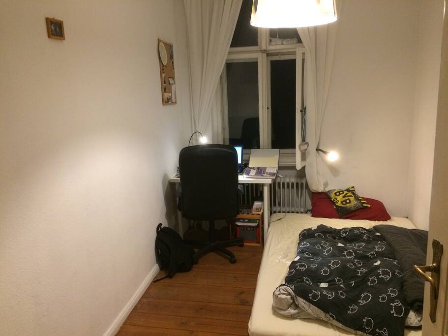 Das Schlafzimmer. Eine großes Bett und ein kleiner Arbeitsplatz.