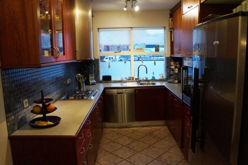 The kitchen with dishwasher and a fridge with ice maker.