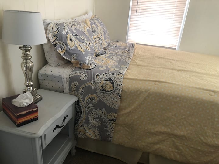 bedroom with queen bed, nightstand lamp and dresser