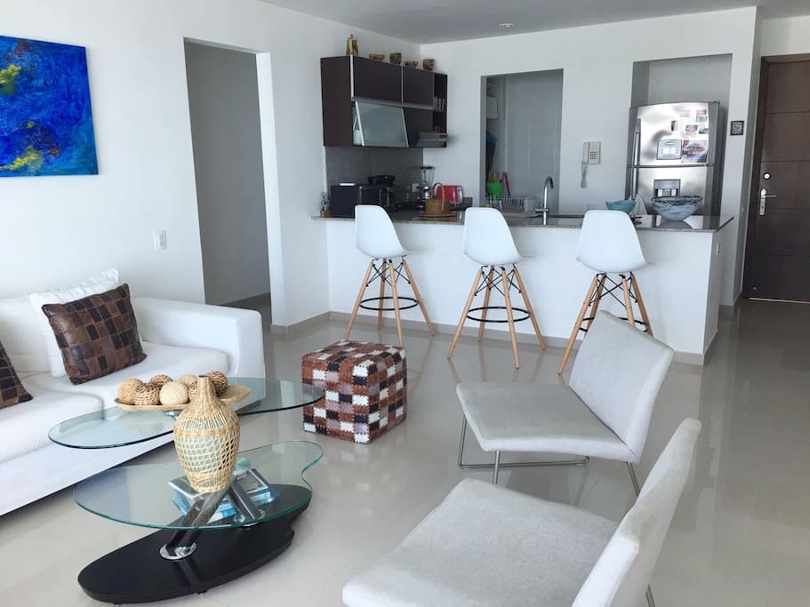 Modern Living Room. Fully-Equipped Kitchen with barstools and area to eat . Laundry Area with Washing and Drying Machine.
Cocina totalmente equipada con taburetes y area para comer. Zona de aseo con Lavadora y Secadora