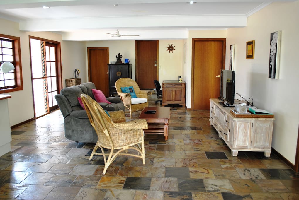Living room with TV, office desk and relaxing chairs
