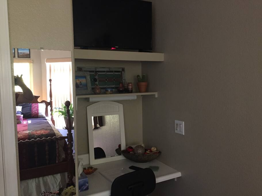 Built in Laptop work station with a flat screen above . Full length mirror to the left.