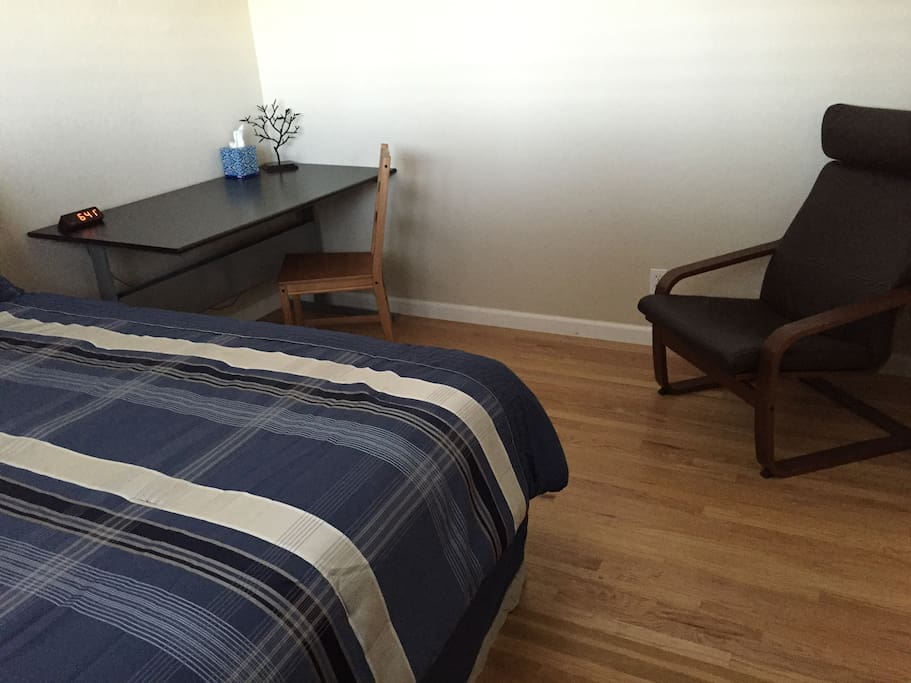 Upstairs bed desk, alarm clock, comfy chair.