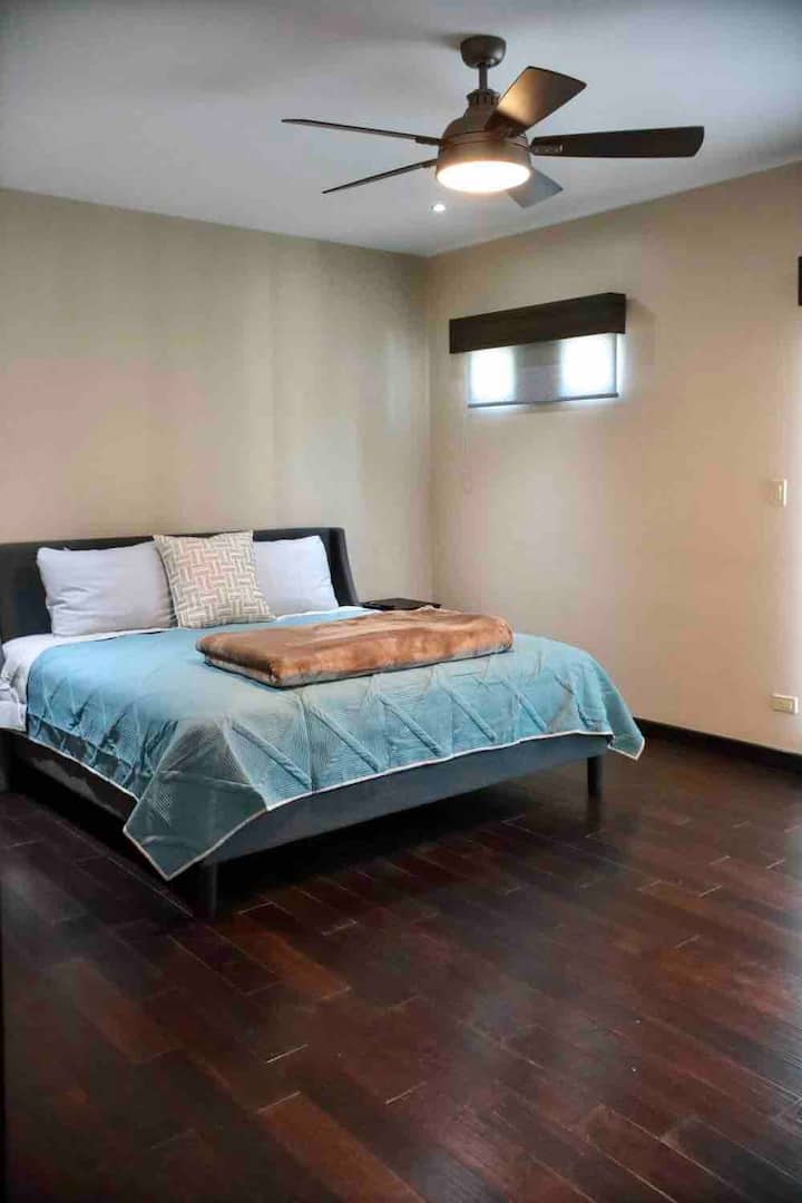 ห้องนอนใหญ่พร้อมเตียงคิงไซส์ ห้องน้ำส่วนตัวห้องแต่งตัวคู่ระเบียงและทีวีขนาด 65 "