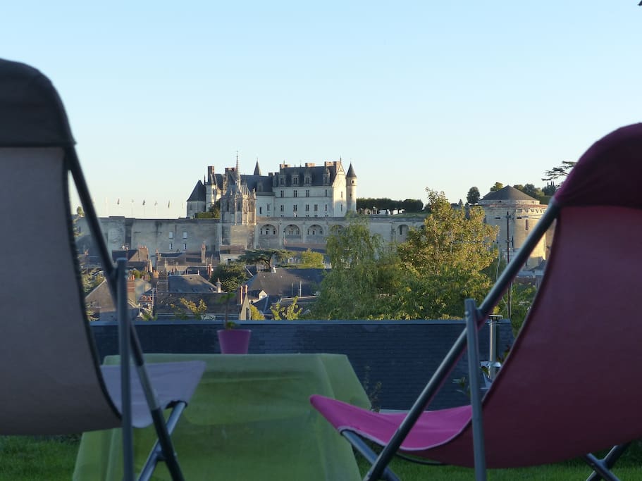 Chaises longues face au château depuis la terrasse du jardin.