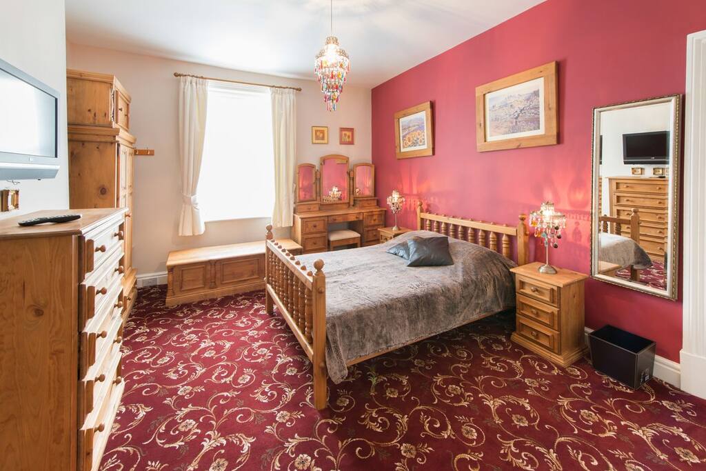 Bedroom 2, pine themed, has a 4ft 6 inch double bed, and a wall mounted TV.