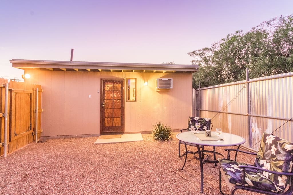 An private and fenced in outdoor sitting area to enjoy the early morning sun or just to relax in the evening. The house is now red stucco and wood fencing.