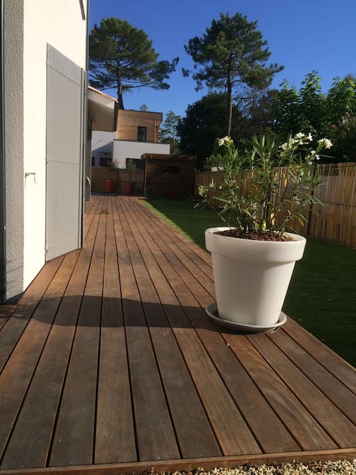 Jardin avec terrasse en bois exotique et pelouse synthétique dernière génération