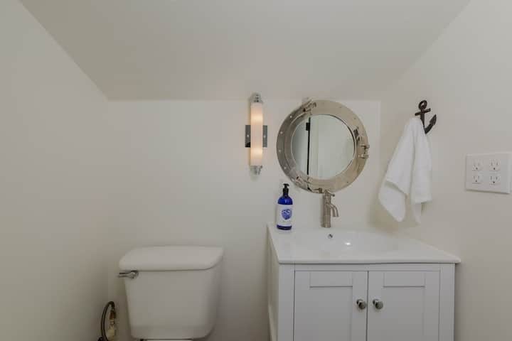 Baño loft con espejo del lavabo. 