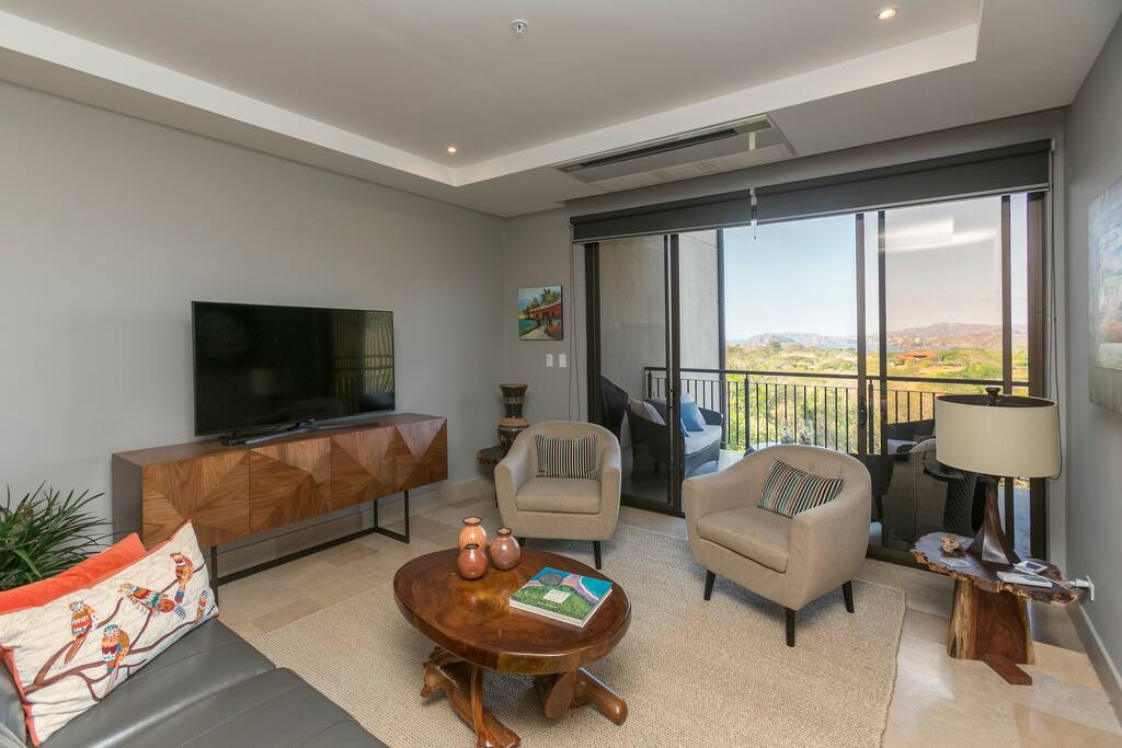 TV area with sofas, armchairs and direct patio access