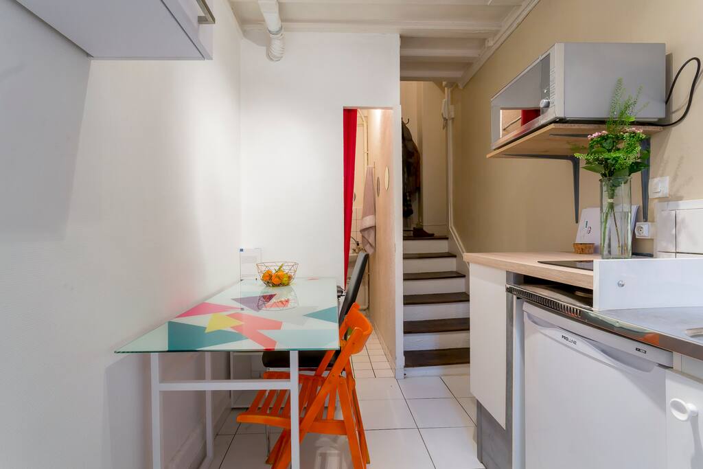 Table avec 2, voire 3 places. Cuisine, four (convertible micro-onde), frigo, cafetière, plaques à induction