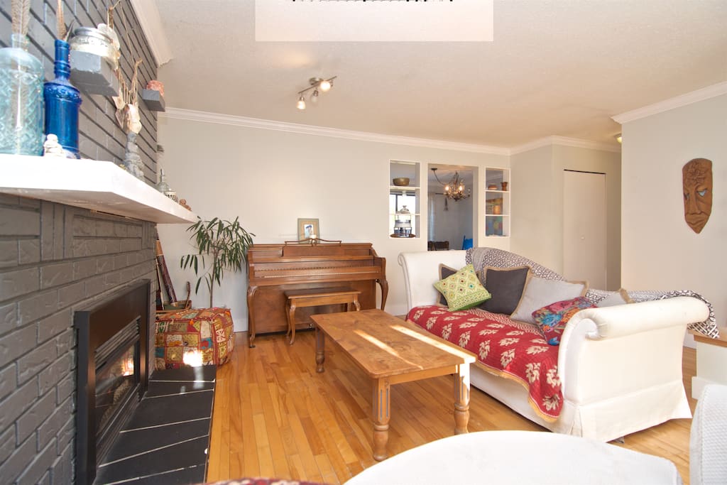 Cozy and open living space with gas fireplace, large comfy round couch perfect for a morning read with a ton of natural light shining through the wall-sized window.