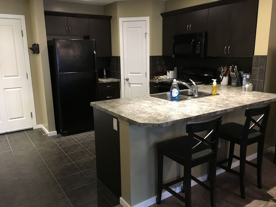 Kitchen has eating bar with chairs, great for cooking and visiting