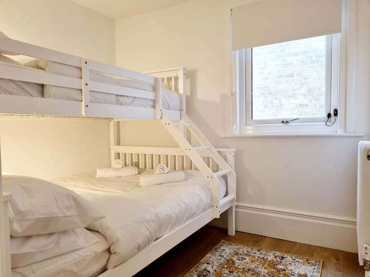 Spálňa 2. Manželská posteľ, poschodová posteľ s jednou posteľou, svetlá na čítanie pre každú osobu, priedušný chránič matraca, paplón a vankúše proti alergii, posteľná bielizeň zo 100% bavlny. Okno vybavené detským bezpečnostným zámkom, neprehliadnuteľná, zatemnená roleta. Vlastná kúpeľňa s WC a kúpeľňou. 