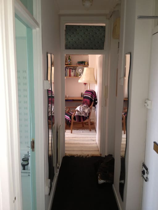 The entrance hallway facing the lounge -front door on the right and toilet on the left with the bedroom behind the camera