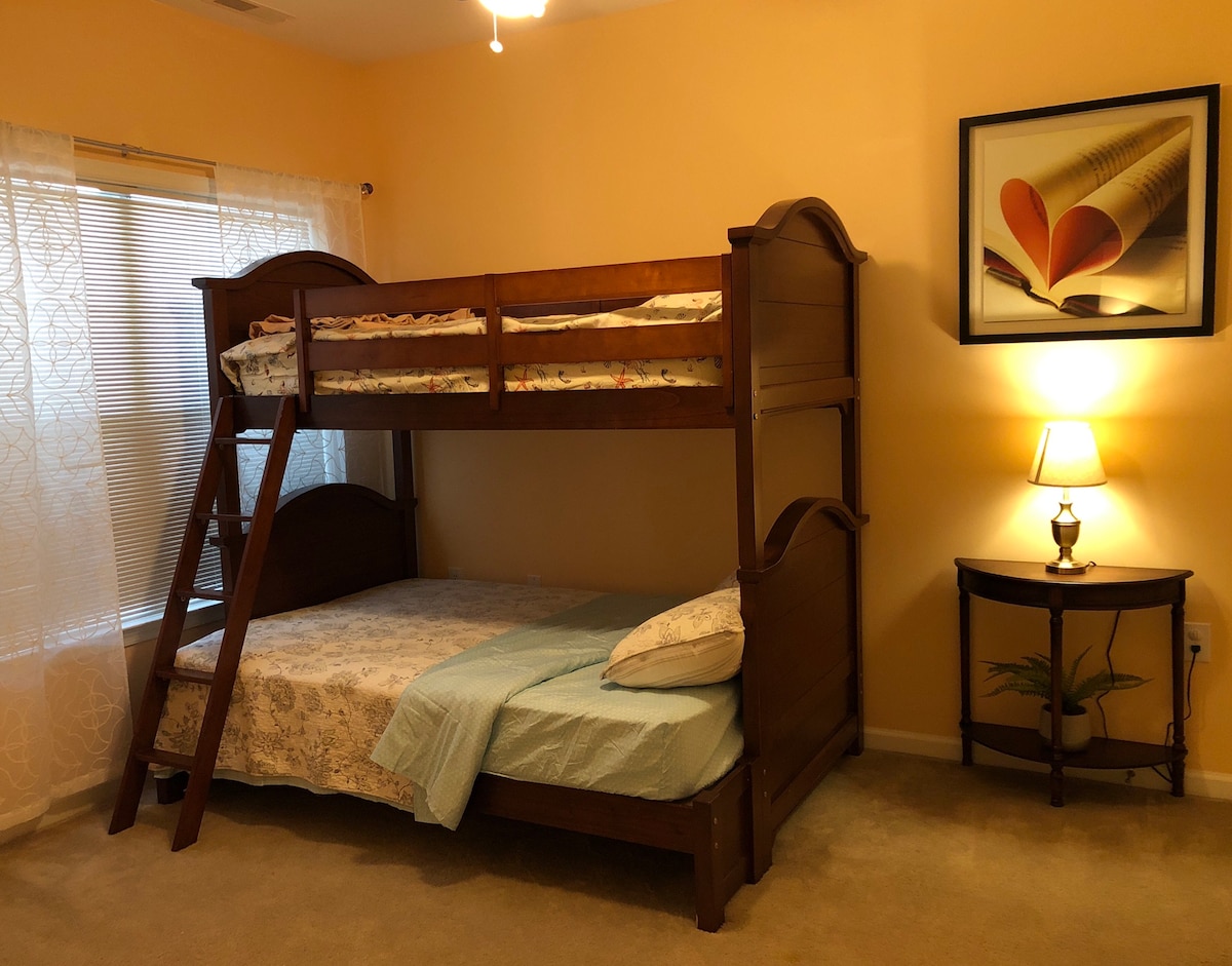 ห้องนอนที่สองมีเตียงแฝดมากกว่าเตียงสองชั้นเต็มและโต๊ะทำงานและเก้าอี้ 